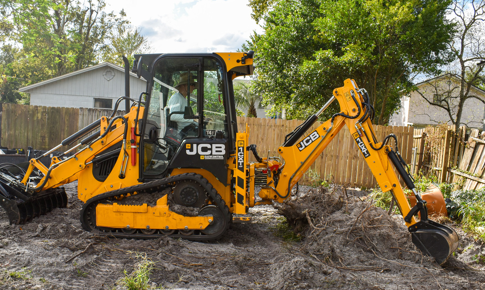 JCB excavator digging in yard