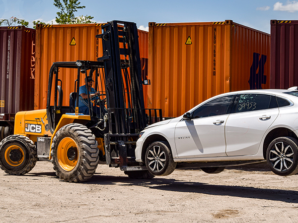 JCB forklift lifting a white car