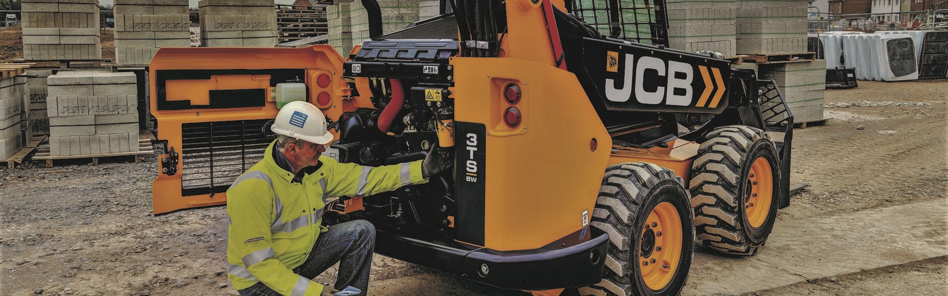 Man with hardhat inspecting JCB teleskid